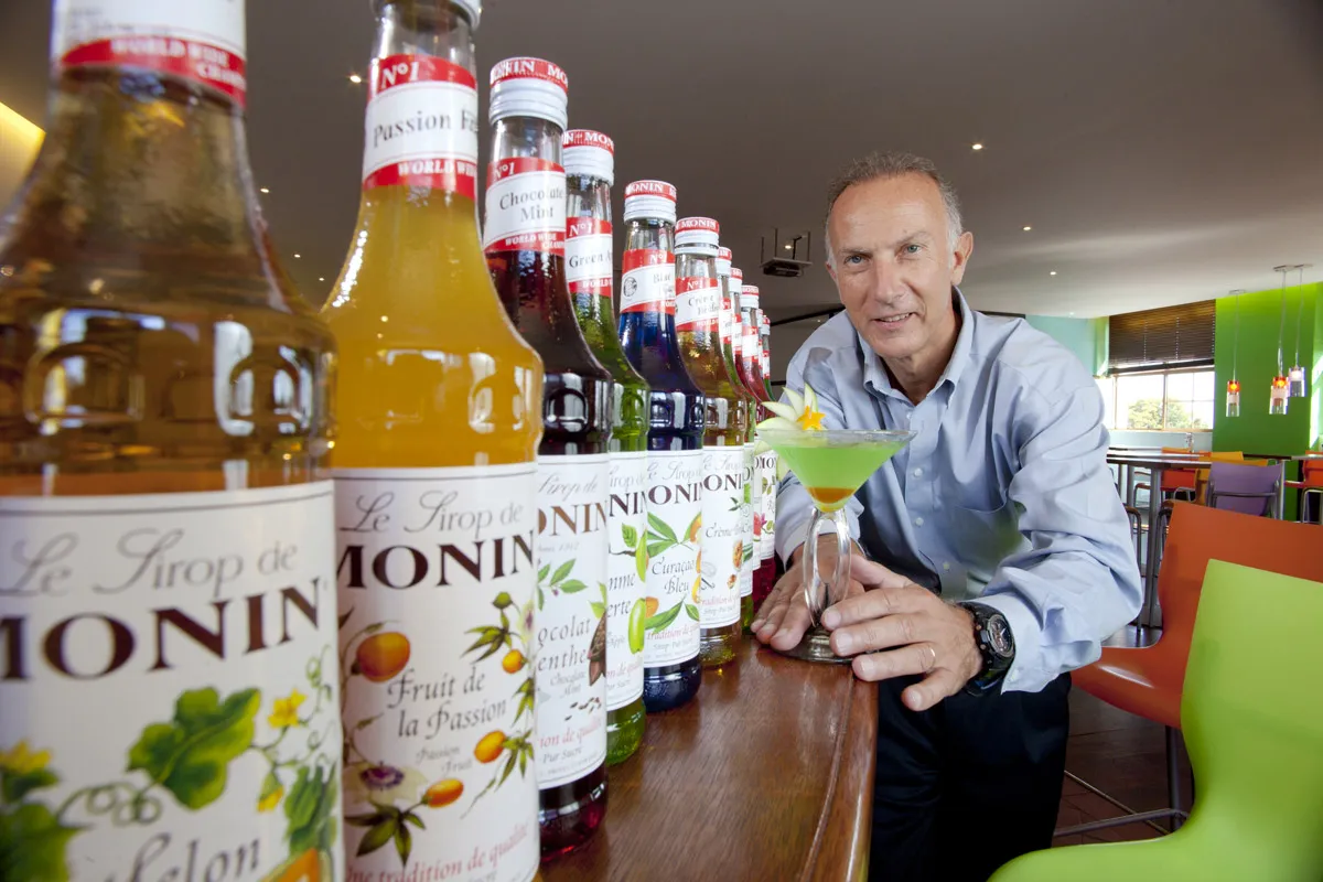 Olivier Monin at a bar lined with Monin syrups