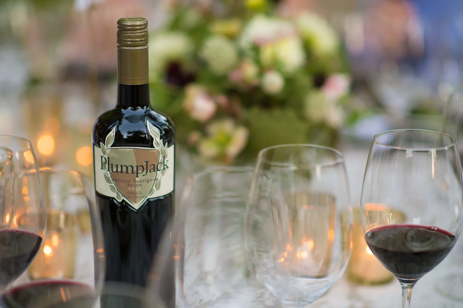 A bottle of PlumpJack wine on a candlelit dinner table